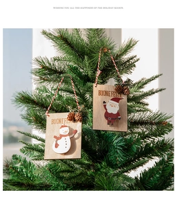 Detail of wooden Christmas ornaments with Santa and snowman hanging on a festive tree