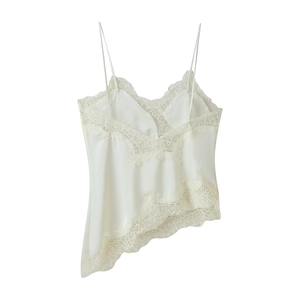 Close-up of white silk camisole featuring delicate lace trim and asymmetric hem design