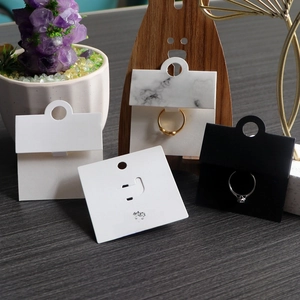 Detail view of marble and black paper jewelry display cards for rings and necklaces