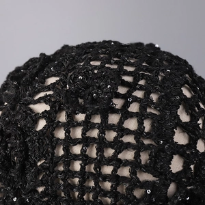 Macro detail of hand-crocheted black mesh headpiece with shimmering silver sequins