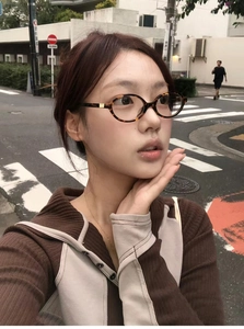 Close-up of tortoise shell oval frame glasses styled with American vintage Y2K fashion