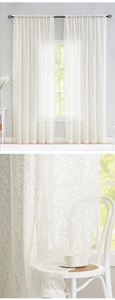 Detail of white lace curtain showing damascus patterns and elegant wavy scalloped edges