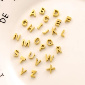 Macro shot of 26 gold stainless steel A-Z letter charms with inlaid cubic zirconia