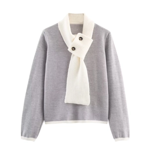 Dettaglio del maglione grigio in maglia con collo a sciarpa bianco e bottoni marroni