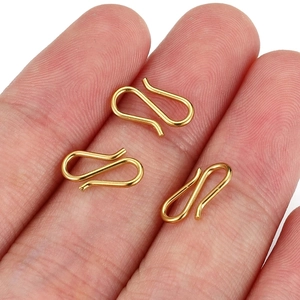 Three gold stainless steel S-shaped jewelry clasps held on fingers for scale