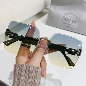 Close-up of rimless butterfly sunglasses with gradient lenses and gold H metal hinge