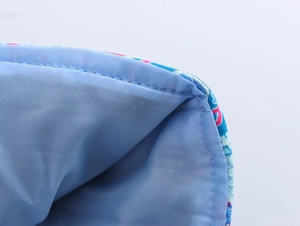 Detailed macro view of light blue fabric lining with precise stitching and floral print