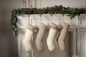 Detailed view of knitted Christmas stockings with fish scale pattern hanging on fireplace