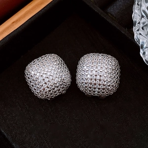 Macro shot of silver cushion-cut stud earrings with micropave zircons on black velvet
