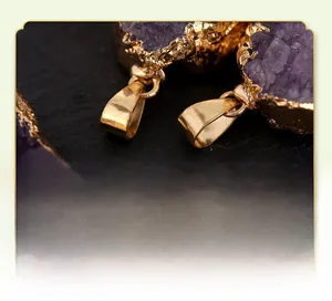 Macro detail of natural irregular amethyst druzy pendants with gold plated edges