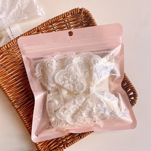 Lace baby headband with floral embroidery in a warm gift setting with woven basket