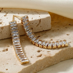 Boucles d'oreilles pendantes dorées avec cristaux et longs pompons sur tissu en soie