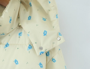 Detail of hooded cotton jacket with blue floral pattern and silver snap buttons