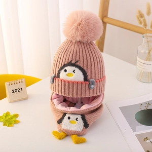 Primer plano de conjunto de gorro y bufanda de punto rosa para bebé con diseño pingüino