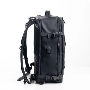 Side view of black travel backpack showing USB charging port and compression straps