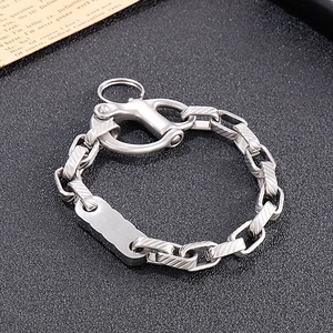 Detail of industrial steel bracelet featuring knurled chain links and lobster clasp