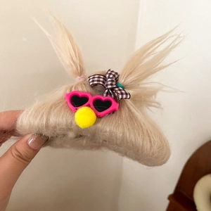 Detail of furry monster hair claw with plaid bow and tiny pink heart sunglasses