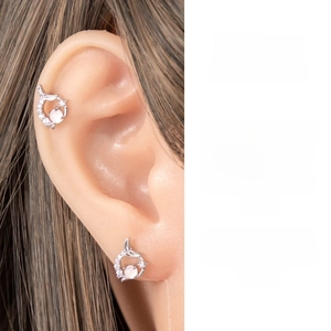 Close-up of silver fishtail earring with pink gemstone and white zircon accents