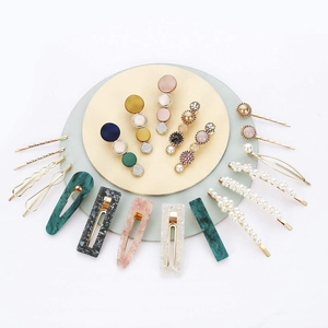 Detail of multi-piece hair clip set with resin marble and pearl designs on a tray
