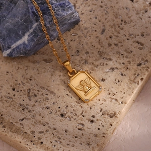 Detailed close-up of gold angel pendant necklace with zircon corners and water wave chain