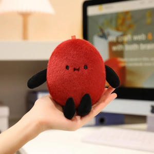 Close-up of small red plush peanut toy held in hand showing soft texture and cute limbs