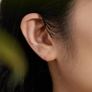Macro view of S925 sterling silver star stud with crystals on model's ear cartilage