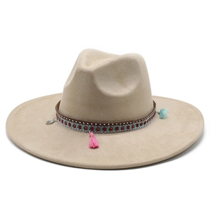 Detail of wide brim suede hat with ethnic ribbon and bohemian tassel decorations