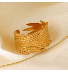 Macro view of 18K gold plated feather ring showing intricate texture on silk background