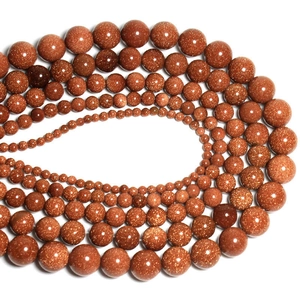 Macro shot of sparkling goldstone round beads arranged in concentric circles by size