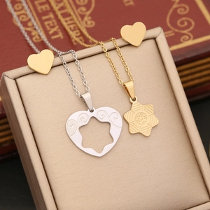 Detail of silver heart and gold hexagon puzzle necklaces displayed on a jewelry box