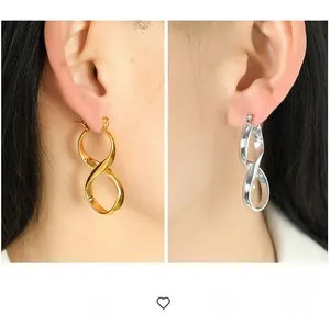 Macro shot of large infinity-shaped metal earrings in gold and silver finish
