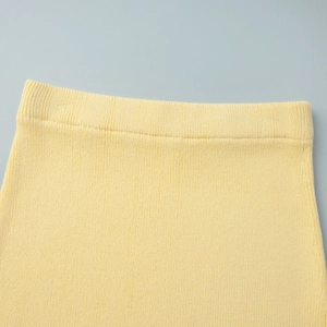 Close-up of pale yellow knit set showing ribbed elastic waistband and fine stitching