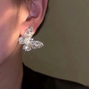 Close-up of elegant butterfly earrings with sparkling cubic zirconia on a model ear