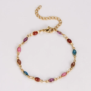 Detail of gold chain bracelet with colorful glitter resin oval charms and lobster clasp