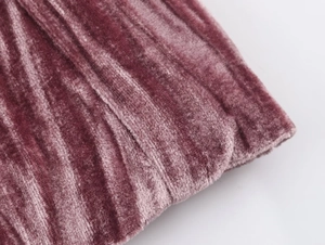 Close-up of pink velvet blazer fabric showing detailed vertical ribbed texture and soft finish