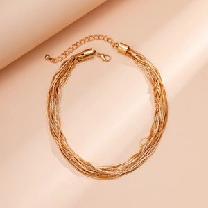 Close-up of golden multi-layer braided chain necklace with lobster clasp and extension