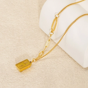 Macro detail of gold-plated square pendant with Rich Chinese character and dual chains