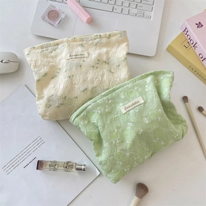 Flat lay of floral texture vanity bags in cream and mint with a stylish brand label