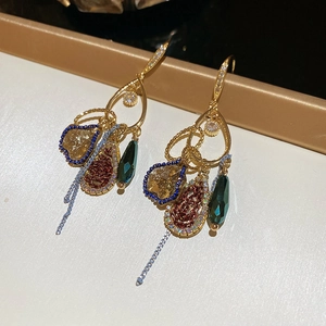 Close-up of vintage French crystal fringe earrings with intricate gold alloy beadwork