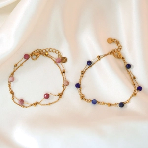 Detail of layered gold stainless steel bracelets with colorful natural stone beads on silk