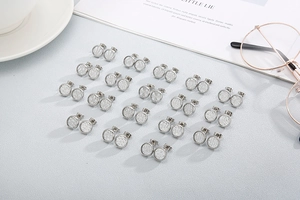 Detailed view of twenty pairs of silver round stud earrings with diverse textured patterns