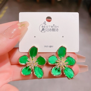 Detail view of emerald green flower earrings with gold edges and S925 silver needles