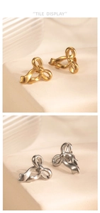 Detail view of gold and silver stainless steel bow stud earrings on a stone base