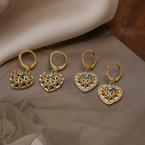 Gold heart drop earrings with blue evil eye and colorful zircon on grey silk
