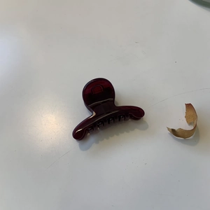 Pince à cheveux crabe bordeaux translucide en résine vue de dessus sur fond blanc neutre