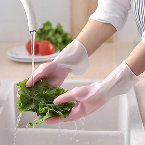 Close-up of pink household cleaning gloves used in a kitchen sink for washing vegetables