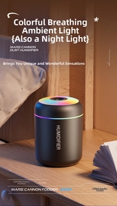 Close-up of a black mini humidifier with a colorful LED ring on a wooden nightstand