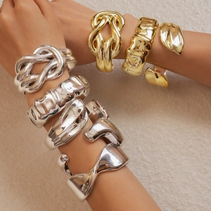 Macro detail of glossy metallic twisted bangle showing the intricate organic gold texture