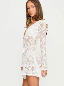 Bohemian white lace mini dress with flared sleeves and crochet details in side view profile