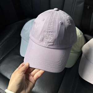 Detailaufnahme der Katzenstickerei auf einer lila Baumwoll-Basecap mit Twill-Gewebe